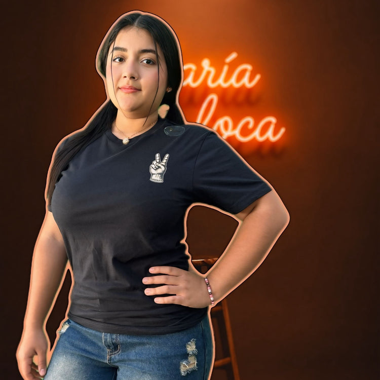 Woman wearing a black t-shirt with a logo in front of a neon sign on a dark background