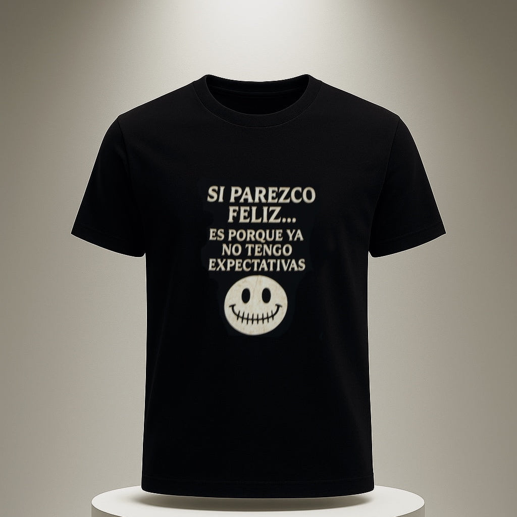 Black t-shirt with white text and smiley face on a white pedestal against a neutral background