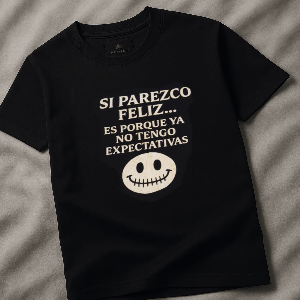 Black t-shirt with white text and smiley face on a gray fabric background