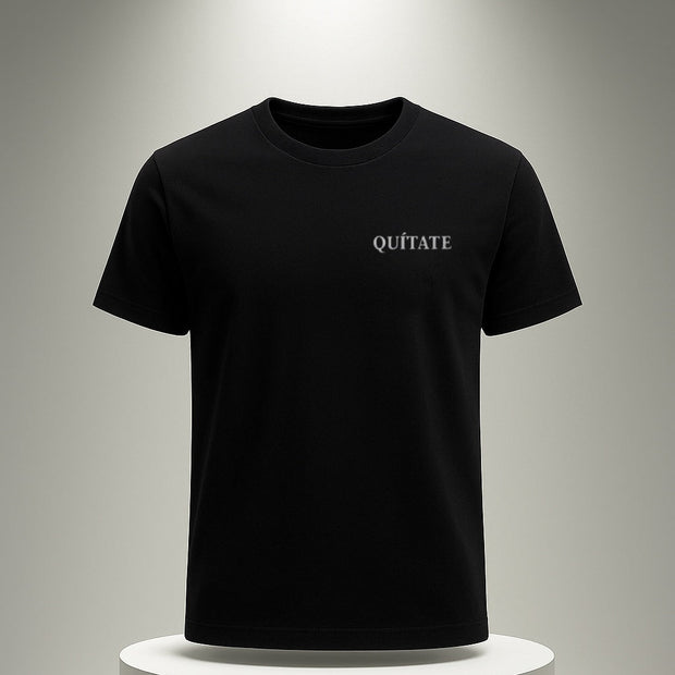 Black t-shirt with 'QUITATE' text on a white pedestal against a gray background
